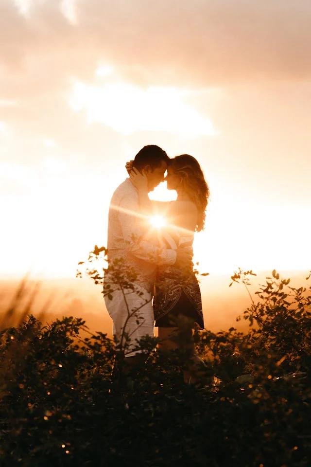 Travaya photographer Couple with sun behind them going down kissing, sun in between their bodies